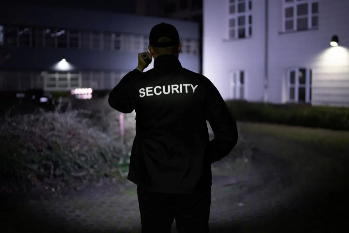Security guard around the perimeter of a property with a flashlight