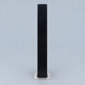A tall, narrow black rectangular stand or post with a square silver metal base, centered against a light gray studio background.