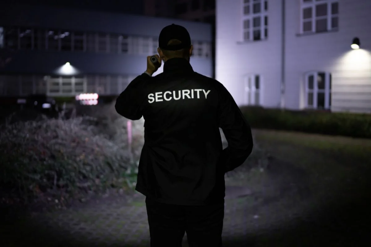 Security guard around the perimeter of a property with a flashlight